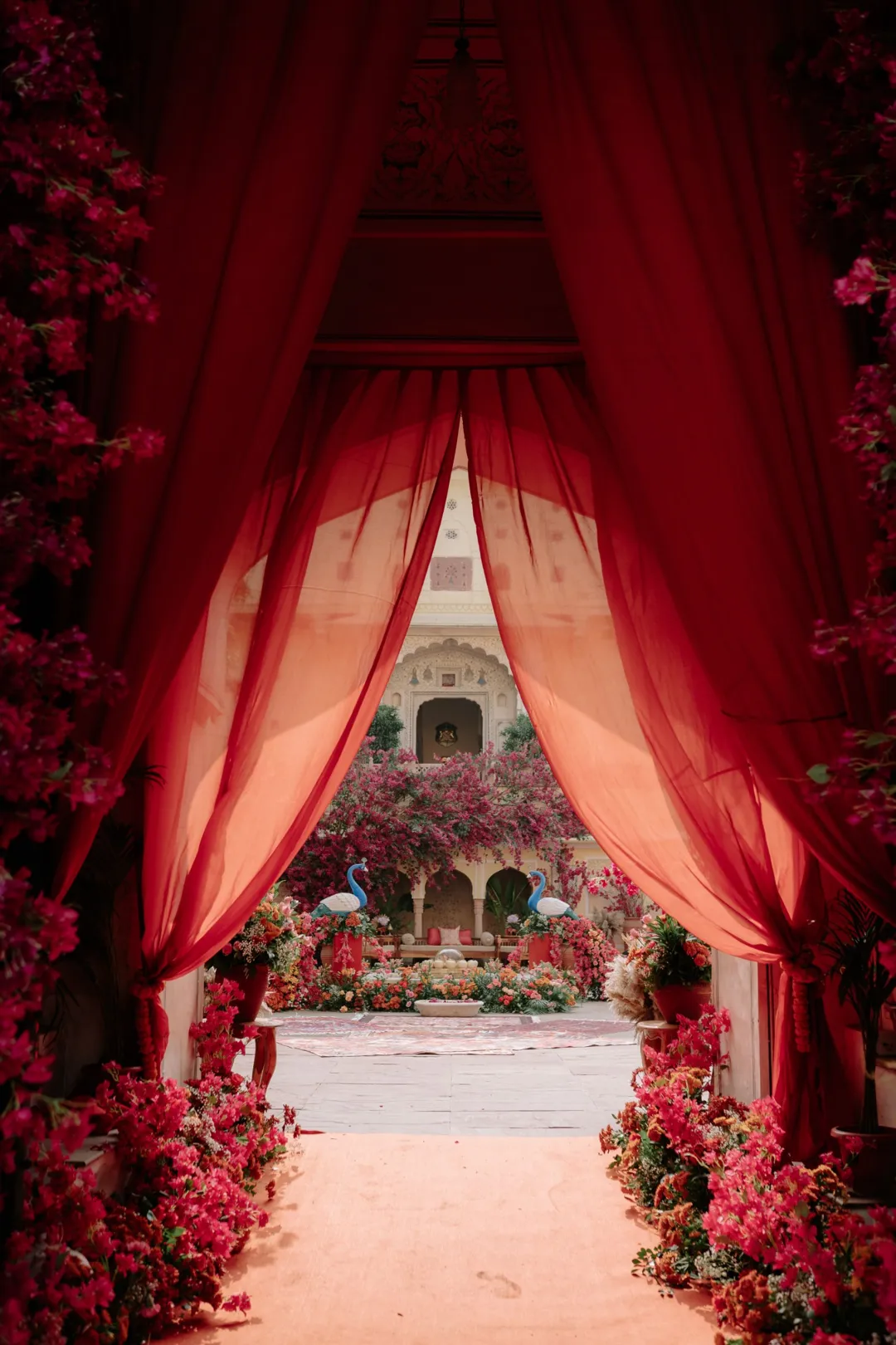 Red curtains opening onto a garden